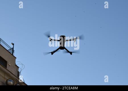 Sagoma di un drone che si libra in aria con un cielo azzurro come sfondo Foto Stock