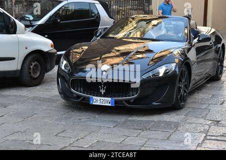 Una Maserati Gran Turismo nera brillante con un piccolo arco bianco sopra il logo dell'auto per le strade di Palermo Foto Stock