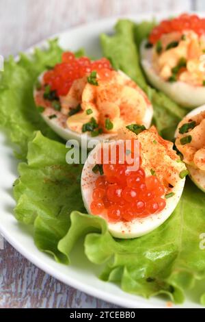 Uova ripiene con caviale di salmone sono un antipasto popolare per ogni occasione. Elegantemente decorate e sapientemente condite, saranno sempre una bella A. Foto Stock