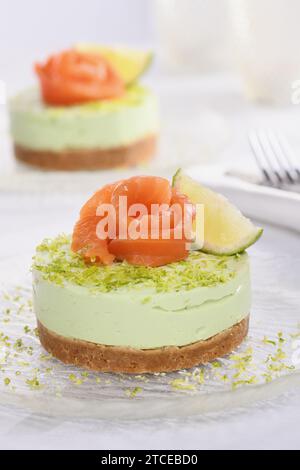 Antipasto timbale a base di avocado, montato con crema di formaggio soffice e lime su crosta corta con salmone. Un'ottima opzione per un menu delle vacanze. Foto Stock