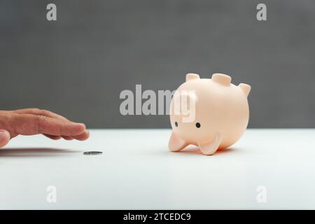 Salvadanaio rovesciato, monete d'oro versate. Aprire il salvadanaio. Spreco di denaro accumulato. l'ultima moneta del salvadanaio. Il concetto di impoverishm Foto Stock