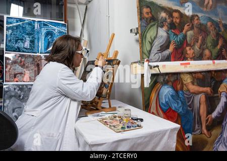 Città del Vaticano, Vaticano. 11 dicembre 2023. La restauratrice chiara Notarstefano lavora su un dipinto presso il "laboratorio di restauro dei materiali di pittura e legno" all'interno dei Musei Vaticani. "Oltre la superficie: Lo sguardo del restauratore" è il titolo dell'iniziativa espositiva con la quale i Musei Vaticani celebrano il centenario della fondazione del "laboratorio di restauro dei materiali di pittura e legno". (Foto di Stefano Costantino/SOPA Images/Sipa USA) credito: SIPA USA/Alamy Live News Foto Stock