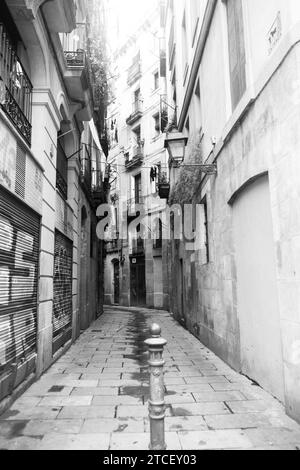 Ripresa verticale di una stradina stretta di Barcellona nello storico quartiere gotico, con edifici molto vicini su entrambi i lati Foto Stock