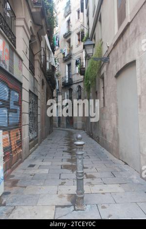 Ripresa verticale di una stradina stretta di Barcellona nello storico quartiere gotico, con edifici molto vicini su entrambi i lati Foto Stock