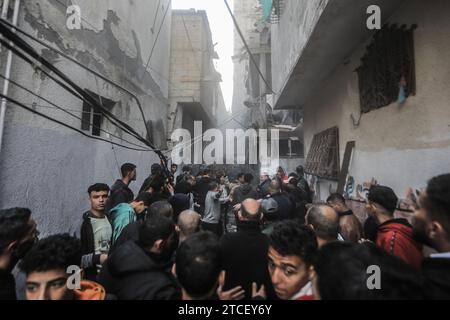 Rafah, territori palestinesi. 12 dicembre 2023. I palestinesi cercano sopravvissuti sotto le macerie a seguito di un attacco aereo israeliano. Credito: Mohammed Talatene/dpa/Alamy Live News Foto Stock