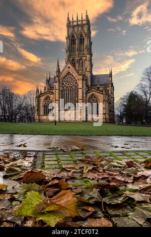 DONCASTER, REGNO UNITO - 8 DICEMBRE 2023. Un vertorama della Chiesa Minster di San Giorgio a Doncaster, South Yorkshire al tramonto con foglie autunnali e copia Foto Stock
