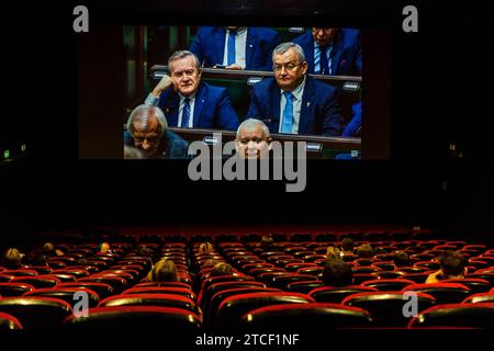 Un pubblico cinematografico assiste a una trasmissione in diretta dei lavori del Parlamento polacco, con Piotr Glinski, Ministro della Cultura del governo PiS, Andrzej Adamczyk, Ministro delle infrastrutture a PiS, Jaroslaw Kaczynski, presidente del diritto e Justiceon la trasmissione scr del Sejm della Repubblica di Polonia nel cinema Kinoteka di Varsavia. Dopo la vittoria della Coalizione Civica, la sinistra, la terza via e la sconfitta di legge e giustizia, il canale Sejm su YouTube ha già un pubblico di diversi milioni di spettatori. L'esposizione del primo Ministro Donald Tusk è stata trasmessa al cinema. Varsavia Polonia Copyright Foto Stock