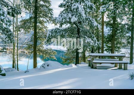 Tavolo da picnic coperto di neve al lago Minnewanka in inverno nelle Montagne Rocciose canadesi Foto Stock