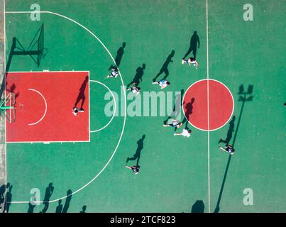 Vista aerea di un gruppo di giovani che giocano a basket su un campo da basket. Foto Stock