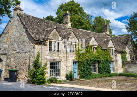 Pittoresca fila di cottage in pietra in fondo a Burford High Street (A361) accanto al ponte sul fiume Windrush a Burford, Oxfordshire, Inghilterra, Regno Unito Foto Stock