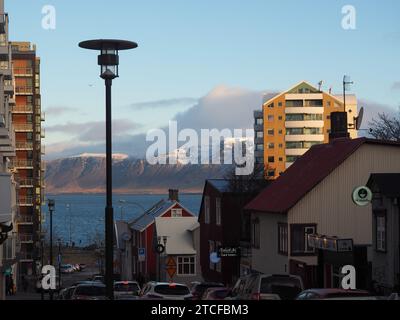 Una vivace strada cittadina di Reykjavik, Islanda, con una varietà di auto e altri veicoli. Foto Stock