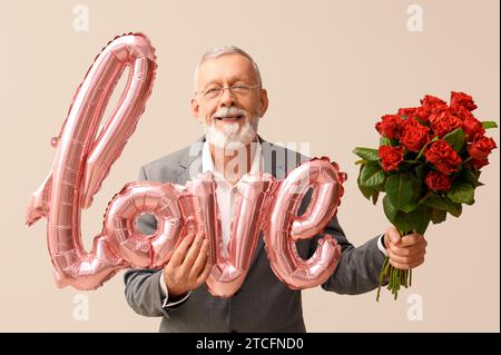 Uomo maturo con bouquet di rose e mongolfiera a forma di AMORE PER le parole su sfondo bianco. Festa di San Valentino Foto Stock