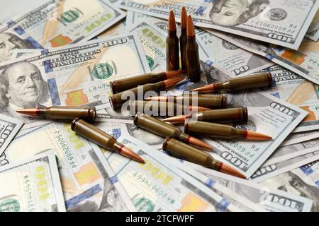 Proiettili militari da combattimento, cartucce giacciono sulle banconote in dollari americani, il concetto di commercio di armi, finanziamento di operazioni militari, militari Foto Stock