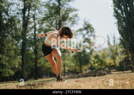 Professionista, femminile, giocatore di badminton che si equilibra per non cadere dopo un tentativo fallito di raggiungere e colpire il volano con la racchetta. Foto Stock