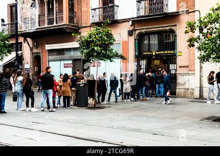 Una fila a Siviglia in Spagna per i biglietti per lo speciale estrazione della lotteria di Natale conosciuta come El Gordo. Si è tenuto il 22 dicembre. Foto Stock