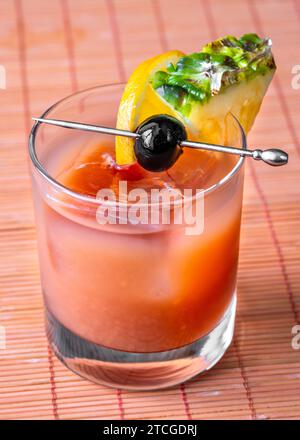 Bermuda Rum Swizzle cocktail guarnito con frutta Foto Stock