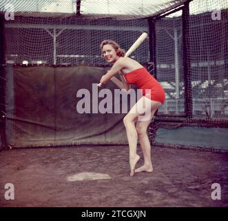 1950: Una donna non identificata è pronta a battere mentre si trova in una gabbia di battuta intorno agli anni '1950 (Foto di Hy Peskin) Foto Stock