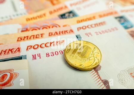 rubli monete contro 5000 rubli banconote sfondo. 10 rubli monete su banconote di carta. Uno stipendio elevato. Affari in Russia. Foto Stock