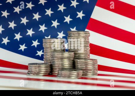 Monete AMERICANE e bandiera americana. Pile di monete d'argento sullo sfondo della bandiera degli Stati Uniti d'America. Il budget americano. il concetto di Foto Stock