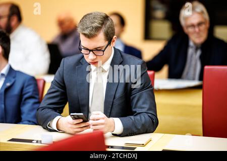 Monaco, Germania. 12 dicembre 2023. Daniel Halemba, membro AfD del parlamento di stato bavarese, siede nel suo seggio all'inizio dell'ultima sessione plenaria prima della pausa invernale nel parlamento di stato bavarese e guarda il suo smartphone. Crediti: Matthias Balk/dpa/Alamy Live News Foto Stock