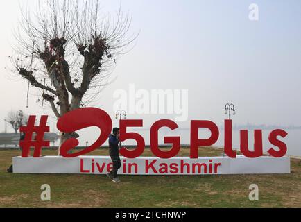 Bharti Airtel svela la tecnologia 5G all'avanguardia 12 dicembre 2023, Srinagar Kashmir, India: Un uomo parla sul suo cellulare mentre Airtel5Gplus viene visto sulle rive del lago dal durante l'esperienza diretta di 5G Plus a Srinagar. Airtel ha annunciato il lancio dei suoi servizi 5G all'avanguardia nell'ottobre 2022 in 8 città in India. Oggi, i servizi di Airtel sono attivi in tutti gli stati e i territori dell'unione dell'India, con oltre 50 milioni di clienti al 1° ottobre 2023. Srinagar Kashmir India Copyright: XFirdousxNazirxxEyepixxGroupx Foto Stock