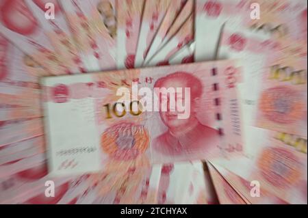 Pechino, Cina. 12 dicembre 2023. ILLUSTRAZIONE - diverse banconote, ognuna con un valore di 100 renminbi cinesi (yuan), giacciono su un tavolo. Credito: Johannes Neudecker/dpa/Alamy Live News Foto Stock
