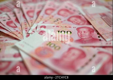 Pechino, Cina. 12 dicembre 2023. ILLUSTRAZIONE - diverse banconote, ognuna con un valore di 100 renminbi cinesi (yuan), giacciono su un tavolo. Credito: Johannes Neudecker/dpa/Alamy Live News Foto Stock
