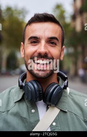 Ritratto verticale di un giovane e bello uomo che sorride e guarda la fotocamera. Foto Stock