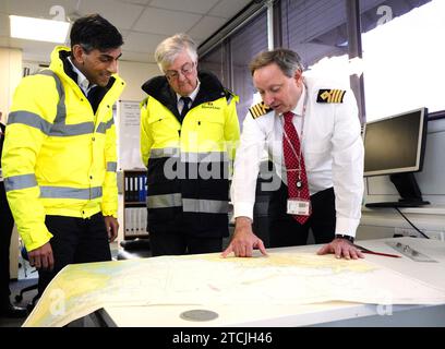 Foto del file datata 23/03/23 del primo ministro Rishi Sunak e del primo ministro del Galles Mark Drakeford con John Goddard, comandante del porto, che guarda le carte durante una visita al porto di Holyhead ad Anglesey, nel Galles del Nord. Mark Drakeford ha detto che si dimetterà da primo ministro del Galles, dicendo: "Quando mi sono candidato alle elezioni come leader del Partito laburista gallese, ho detto che mi sarei dimesso durante l'attuale mandato di Senedd. Quel momento è giunto." Data di emissione: Mercoledì 13 dicembre 2023. Foto Stock