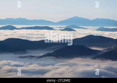 Alba sulle cime delle montagne con nebbia e nuvole Foto Stock