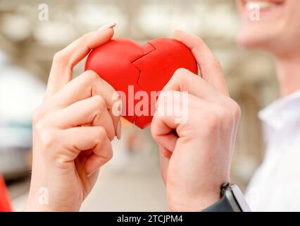 Coppia felice che cerca di collegare due pezzi di cuore - la relazione, nel concetto d'amore Foto Stock