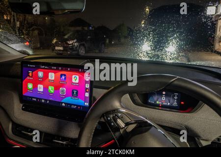 Apple CarPlay viene visualizzato sul cruscotto di un'auto di notte. Foto Stock