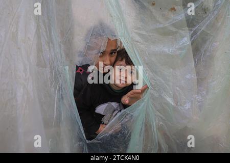 Khan Younis. 13 dicembre 2023. I palestinesi sono visti in un rifugio temporaneo nella città meridionale di Khan Younis nella Striscia di Gaza, 13 dicembre 2023. Secondo le Nazioni Unite (ONU), circa 1,9 milioni di persone a Gaza, ovvero il 85% della sua popolazione, sono state sfollate internamente, alcune delle quali sono state sfollate più volte. Crediti: Rizek Abdeljawad/Xinhua/Alamy Live News Foto Stock