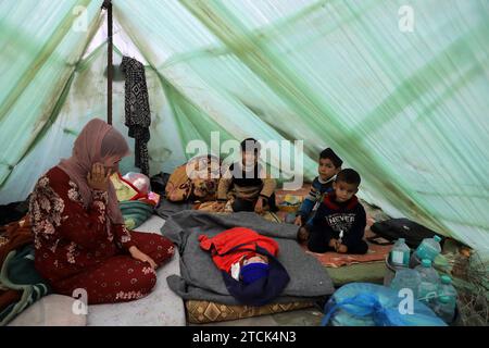 Khan Younis. 13 dicembre 2023. I palestinesi sono visti in un rifugio temporaneo nella città meridionale di Khan Younis nella Striscia di Gaza, 13 dicembre 2023. Secondo le Nazioni Unite (ONU), circa 1,9 milioni di persone a Gaza, ovvero il 85% della sua popolazione, sono state sfollate internamente, alcune delle quali sono state sfollate più volte. Crediti: Rizek Abdeljawad/Xinhua/Alamy Live News Foto Stock