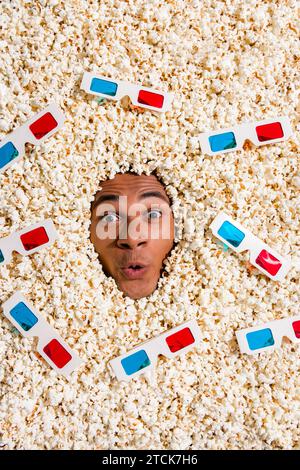 Foto dall'alto di shock Surprise Guy in pop corn completo con specifiche tridimensionali goditi un film variegato in un film isolato Foto Stock