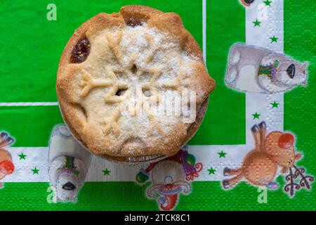 La torta mince Tesco, ricca e decadente, con pasta sfoglia al burro, è stata preparata su un tovagliolo natalizio Foto Stock