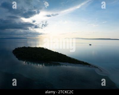 La luce del mattino illumina l'isola di Koon in Indonesia. Le barriere coralline di quest'isola e i mari circostanti supportano un'elevata biodiversità marina. Foto Stock