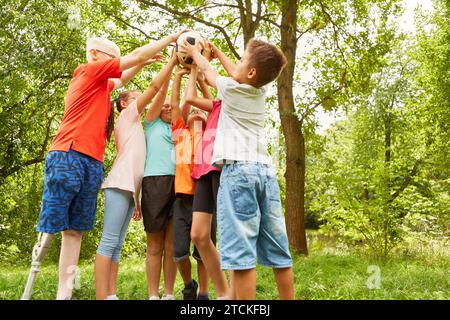 Amici maschi e femmine che tengono una palla da calcio mentre si trovano al parco Foto Stock