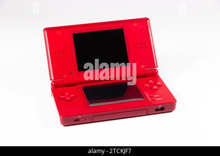 Console di gioco portatile portatile Nintendo DS lite in plastica rossa isolata sullo sfondo dello studio con accessori e scheda Foto Stock
