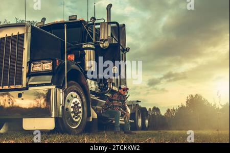 Camionista CDL professionale caucasico negli anni '40 e nel suo trattore semi-camion Foto Stock