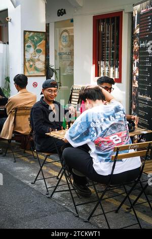 Un gruppo eterogeneo di persone che si gustano un pasto insieme fuori da un ristorante Foto Stock