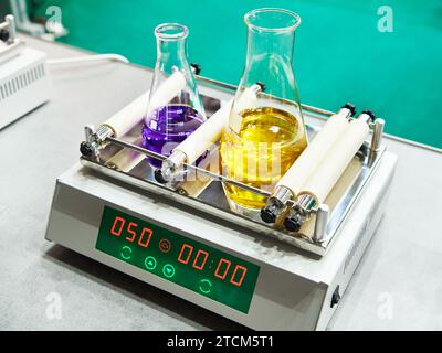 Agitatore da laboratorio e matracci con soluzione Foto Stock