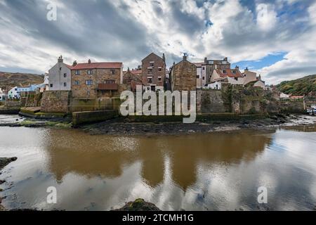 Case riflesse nell'acqua, Staithes, North Yorkshire Foto Stock