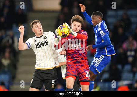 Il portiere del Millwall Matija Sarkic (centro) rivendica la palla da Patson Daka di Leicester City durante la partita del campionato Sky Bet al King Power Stadium di Leicester. Data foto: Mercoledì 13 dicembre 2023. Foto Stock