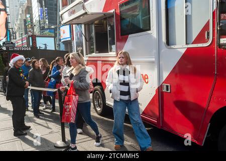 La gente aspetta on line la cioccolata calda gratuita all'attivazione del marchio del film "Candy cane Lane" di Amazon prime Videos con Eddie Murphy, a Times Square a New York sabato 2 dicembre 2023. (© Richard B. Levine) Foto Stock