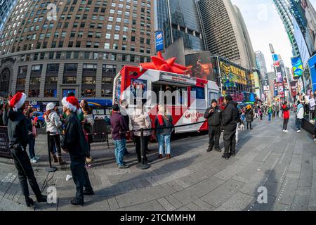 La gente aspetta on line la cioccolata calda gratuita all'attivazione del marchio del film "Candy cane Lane" di Amazon prime Videos con Eddie Murphy, a Times Square a New York sabato 2 dicembre 2023. (© Richard B. Levine) Foto Stock