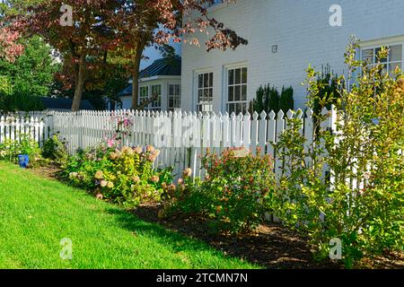 Tradizionale recinzione per picchetti dipinta di bianco intorno a una casa nel quartiere storico di Fredericksburg, Virginia Foto Stock