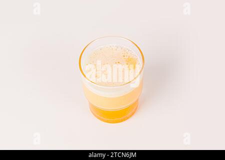 Una compressa effervescente di vitamina C arancia è caduta e si dissolve in un bicchiere d'acqua con bolle isolate su fondo bianco Foto Stock
