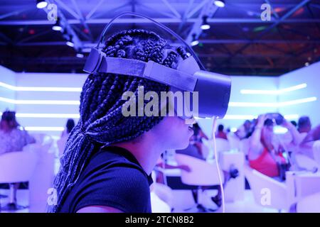 Ragazza di profilo con trecce che indossa occhiali per realtà virtuale VR con sfondo a luci al neon verticalmente Foto Stock