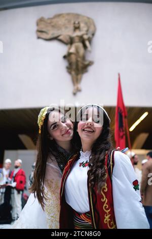 Tirana, Albania - novembre 28: Due studentesse in tradizionale abbigliamento albanese si posano di fronte alla statua di madre Teresa al Palazzo Foto Stock